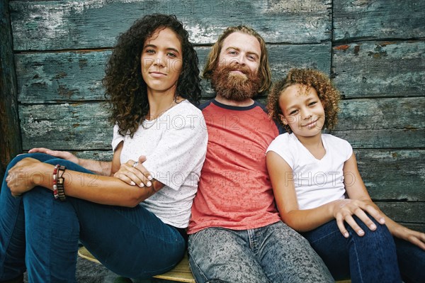 Smiling family sitting outdoors