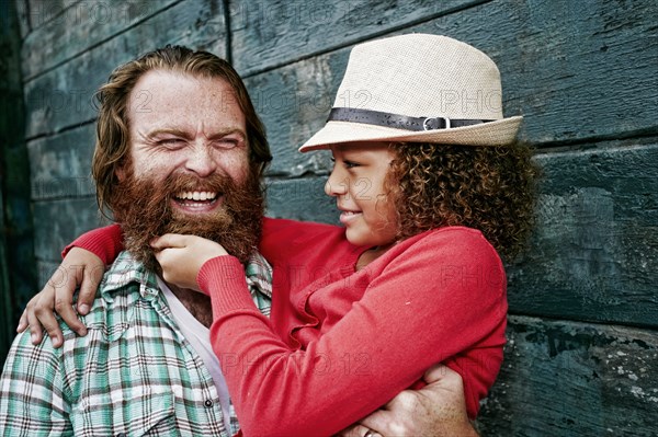 Girl pulling beard of father