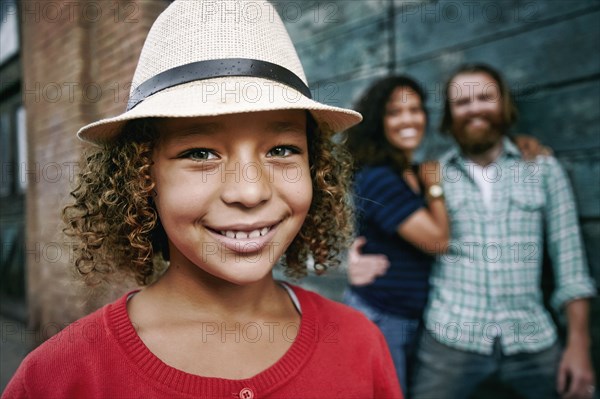 Smiling girl wearing fedora outdoors