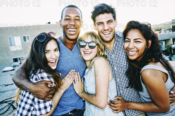 Friends hugging on urban rooftop