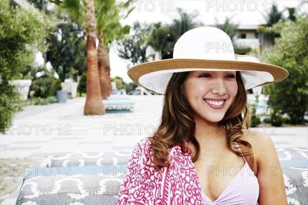 Hispanic woman wearing sun hat outdoors