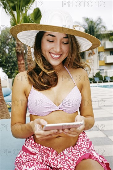 Hispanic woman using digital tablet outdoors