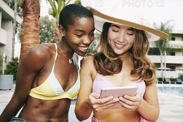 Women using digital tablet outdoors