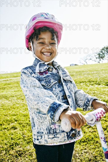 Black girl wearing helmet on scooter