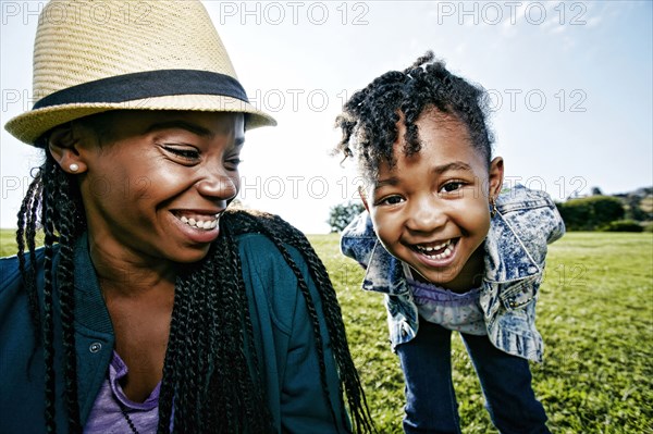 Black mother and daughter playing in park