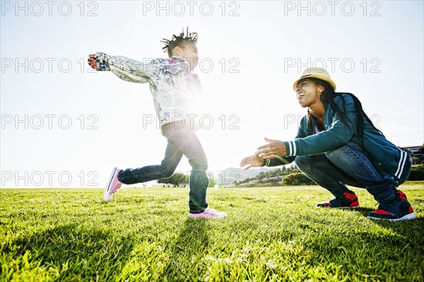 Black mother and daughter playing in park