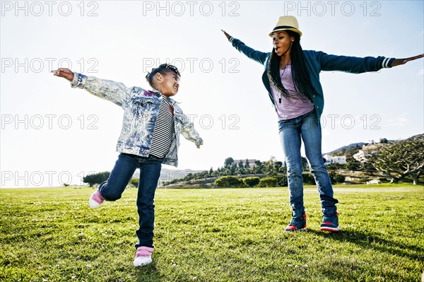 Black mother and daughter playing in park