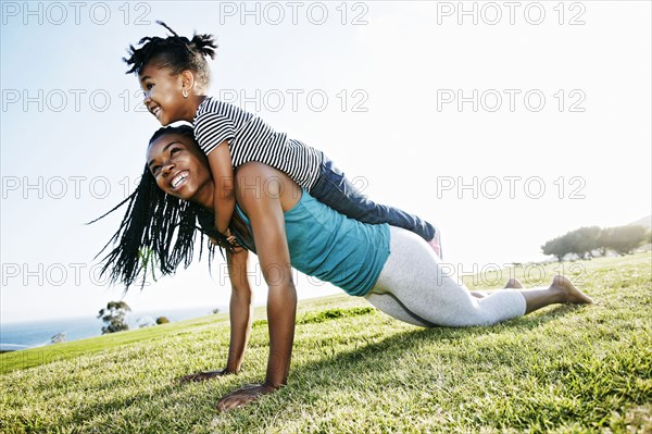 Black mother and daughter practicing yoga