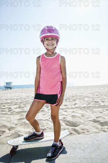 Girl riding skateboard at beach