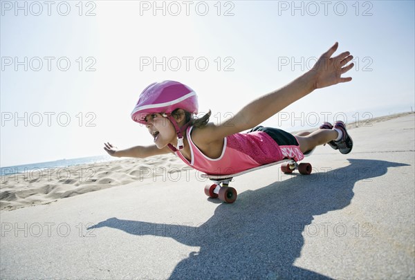 Girl riding skateboard at beach