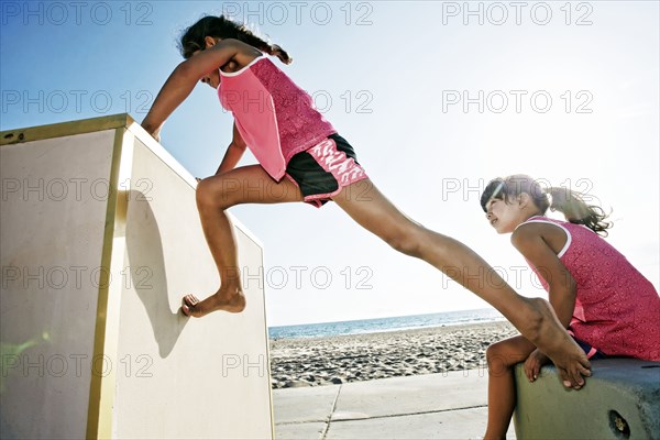 Girls climbing structure at beach