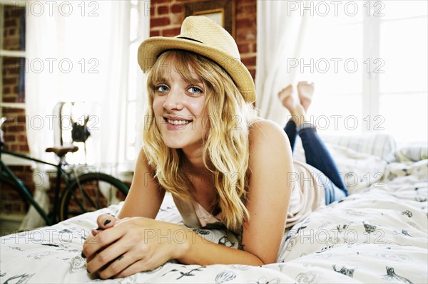 Caucasian woman laying on bed in bedroom