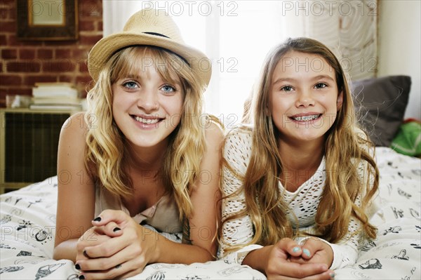 Mother and daughter smiling on bed