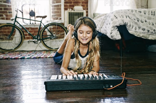 Native American girl playing keyboard in bedroom