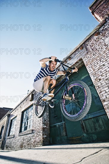 Caucasian man jumping on BMX bike