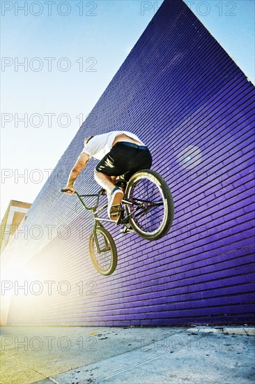 Caucasian man jumping on BMX bike