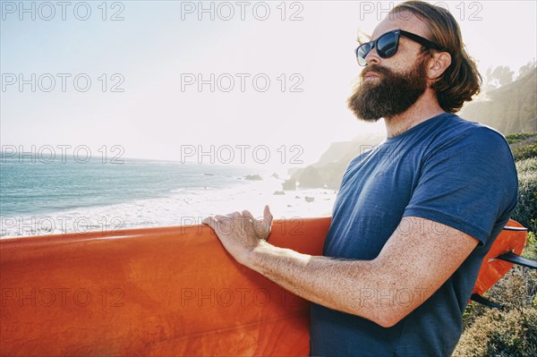 Caucasian man holding surfboard at beach