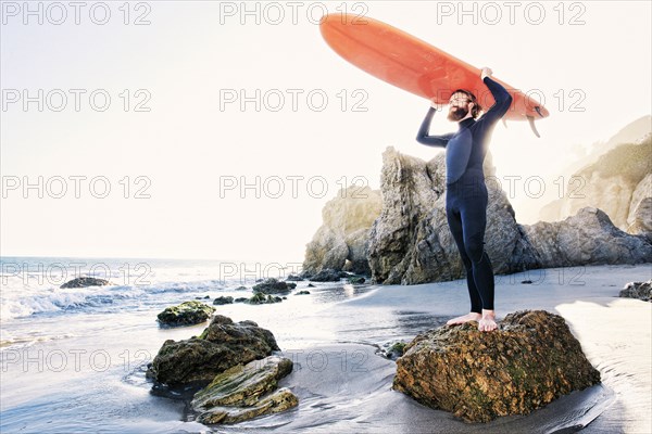 Caucasian man holding surfboard at beach