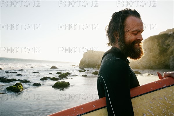 Caucasian man holding surfboard at beach