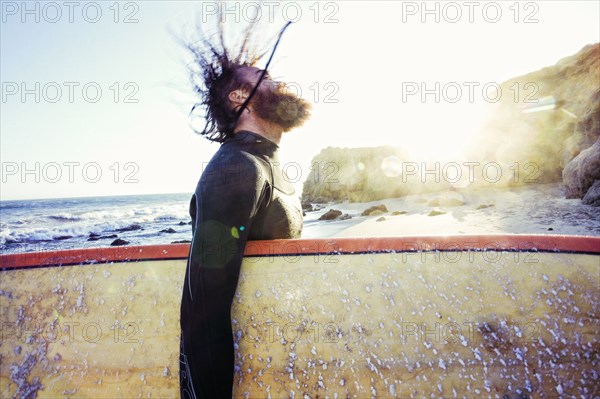 Caucasian man holding surfboard at beach