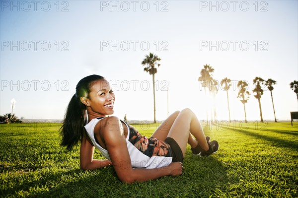 Mixed race athlete laying in park