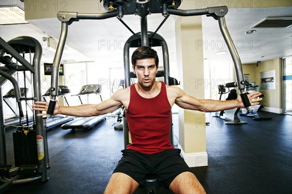 Caucasian man working out in gymnasium