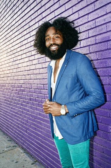 Mixed race man smiling outdoors near purple wall