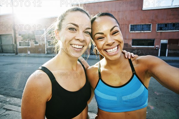 Smiling athletes hugging outdoors