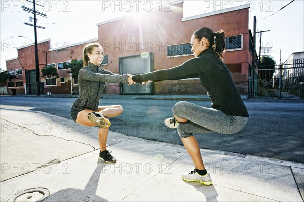 Athletes balancing on sidewalk