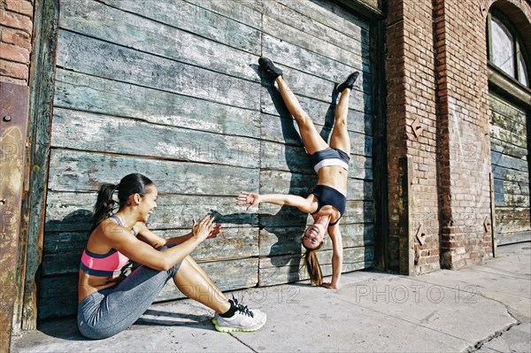 Athlete doing handstand on sidewalk