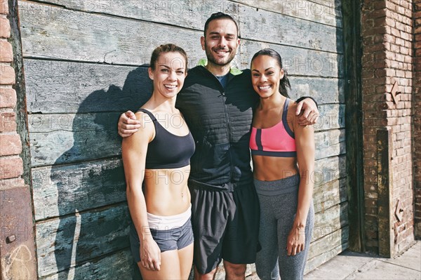 Smiling athletes hugging on sidewalk