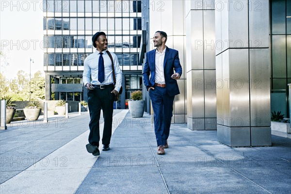 Businessmen talking outside office building