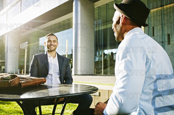 Businessmen talking at table outdoors