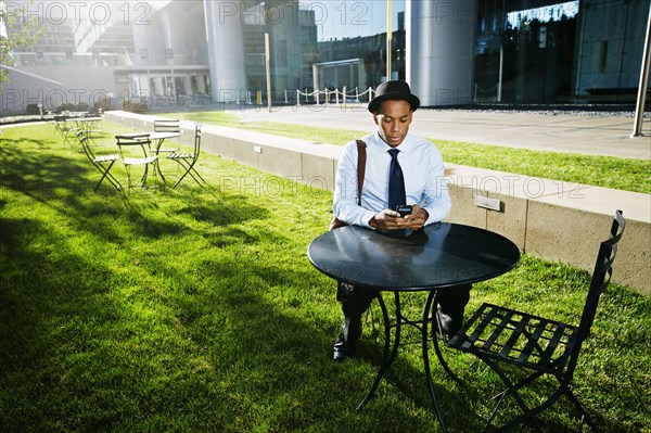 Black businessman using cell phone outdoors