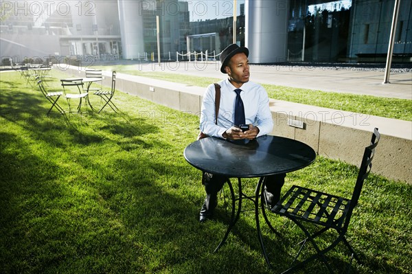 Black businessman using cell phone outdoors