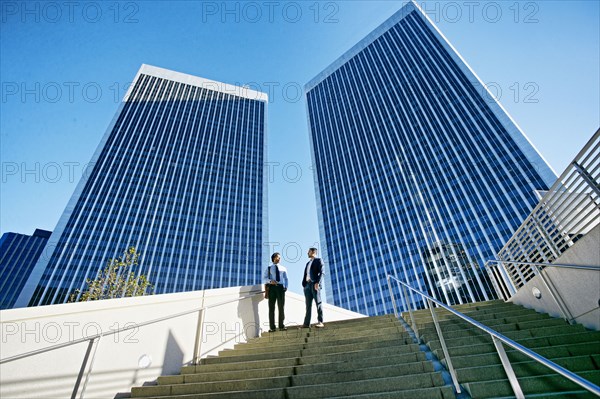 Businessmen talking under highrise buildings