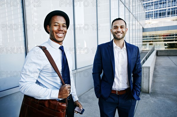 Businessmen smiling outside office building