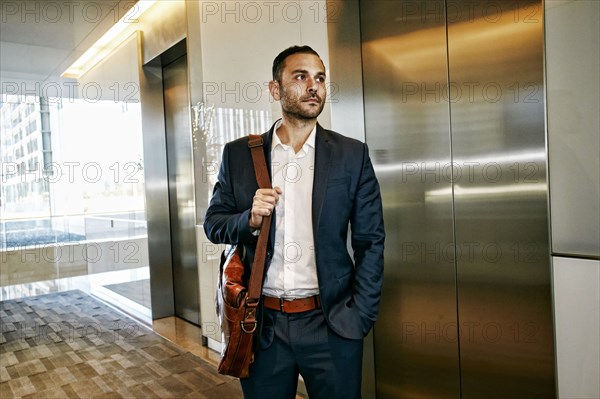 Caucasian businessman waiting for office elevator