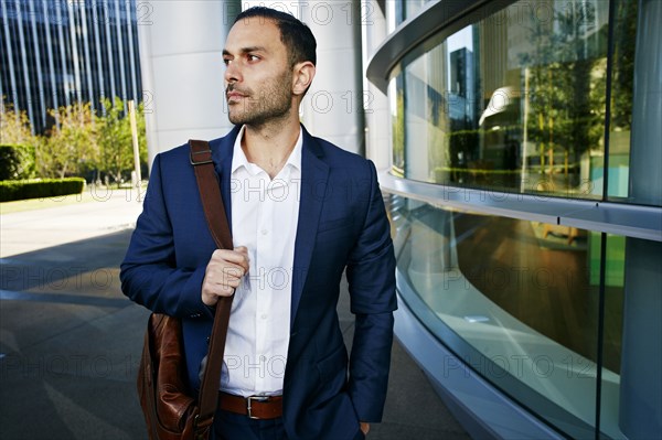 Caucasian businessman walking outside office building