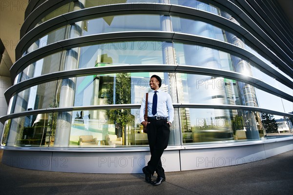Black businessman smiling outside office building