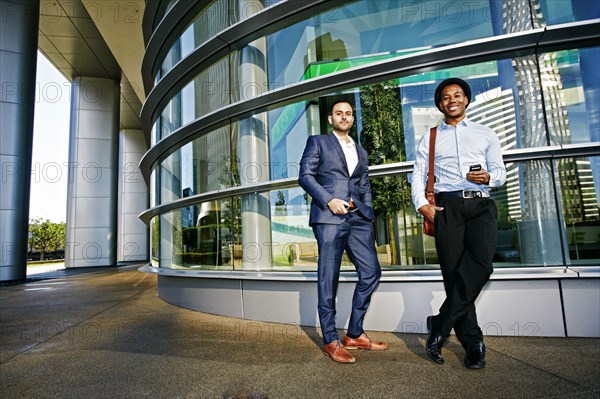 Businessmen smiling outside office building