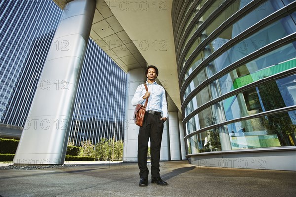 Black businessman standing outside office building