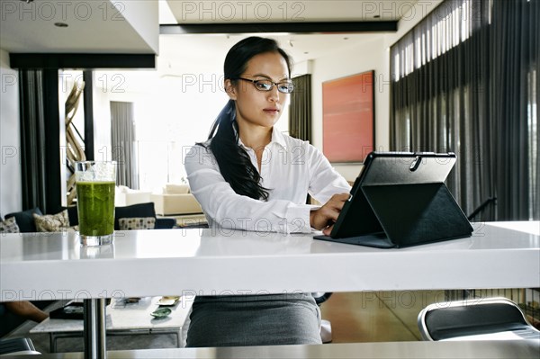 Chinese businesswoman using digital tablet at counter