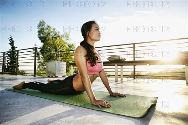 Chinese woman practicing yoga on balcony