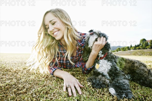 Caucasian woman petting dog in park