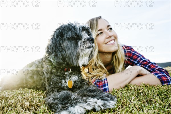 Caucasian woman and dog laying in park