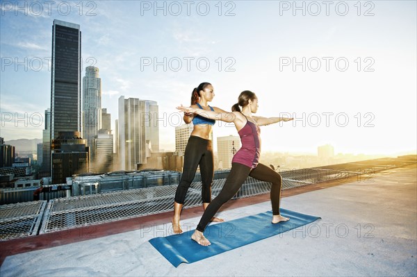 Mixed race woman practicing yoga on urban rooftop