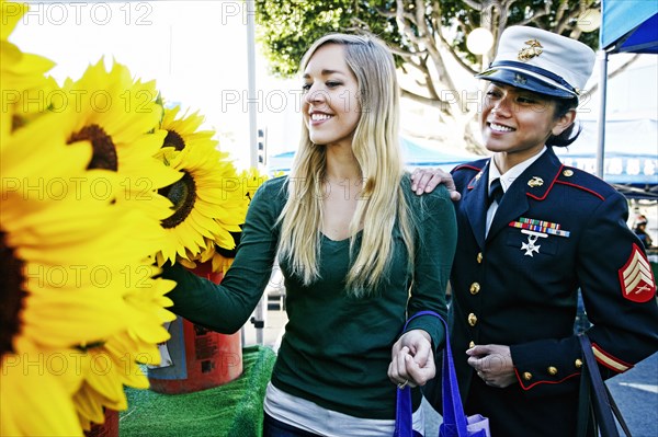 Asian soldier and friend shopping in flower market