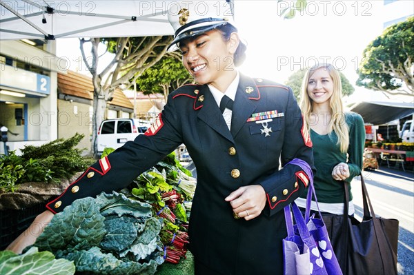 Asian soldier and friend shopping in farmers market