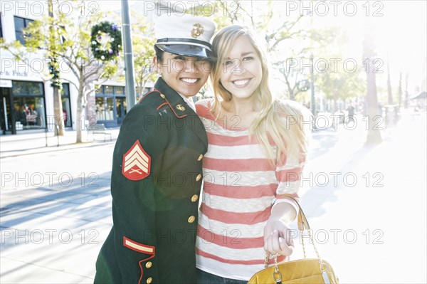 Asian soldier and friend smiling outdoors